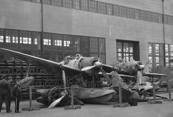 Wreck of a pontoon plane at NAS, 1947, with hangar in background